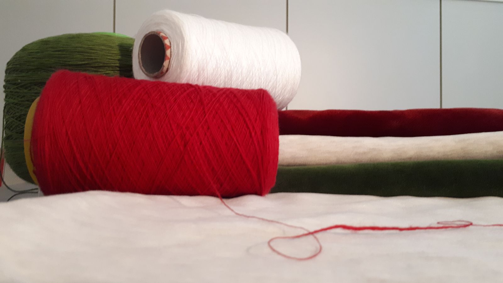 Rocche di filato rosso, verde e bianco